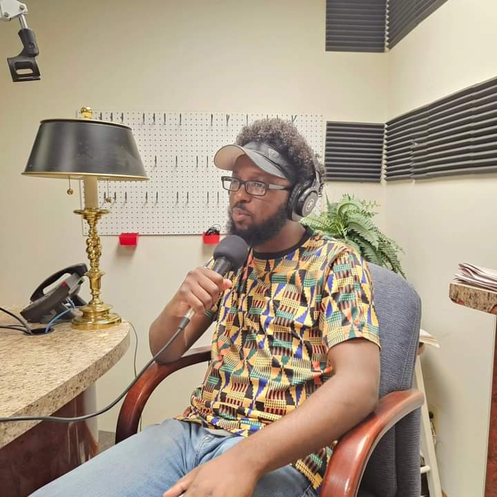 DaVante' Goins recording in a radio studio with headphones and a microphone