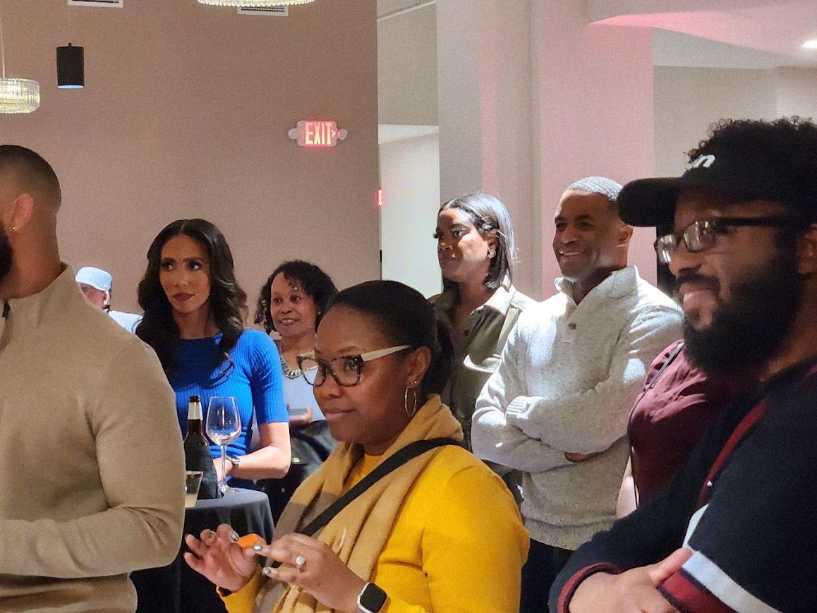 Guests listening at an evening community event hosted by DaVante' Goins