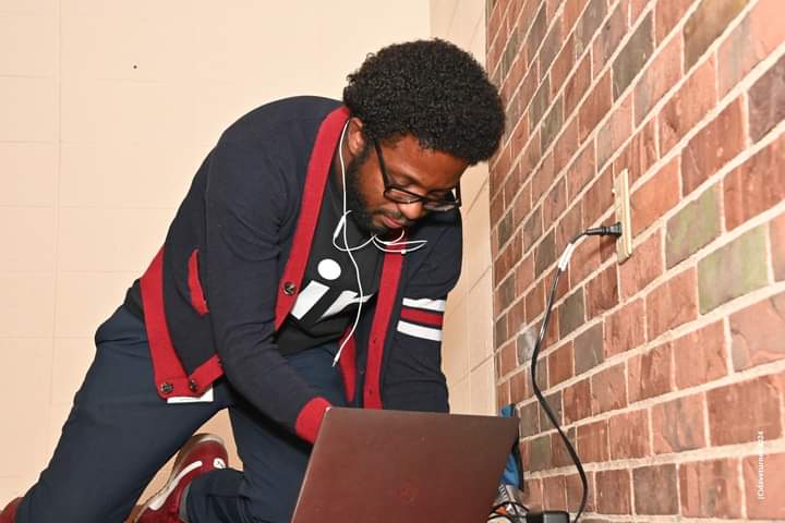 DaVante' Goins working on a laptop on location