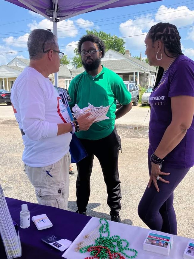 DaVante' Goins talking with community members at an outdoor event